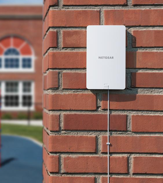 External wireless access point mounted on a brick wall for full-property Wi-Fi coverage