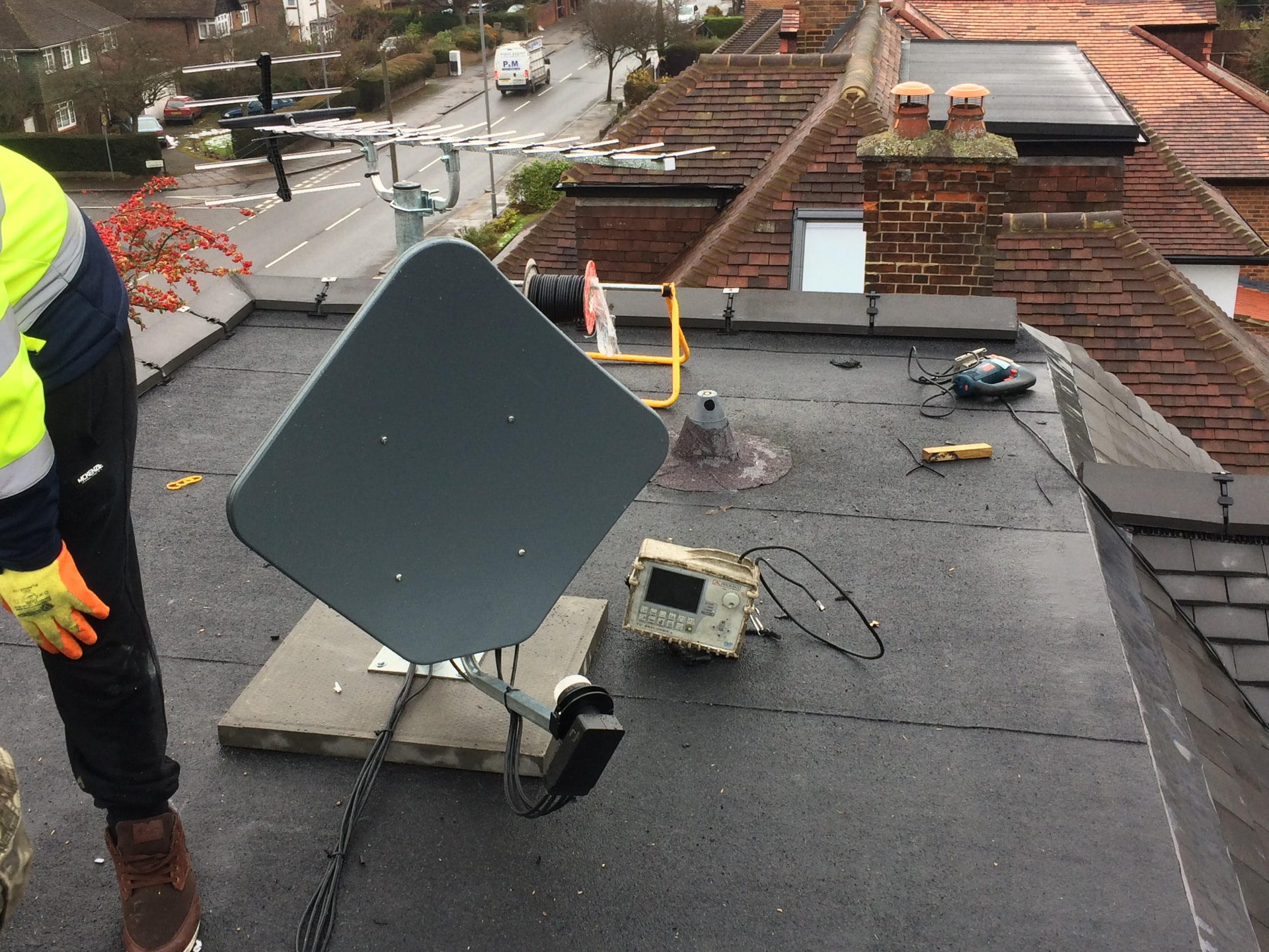 Satellite dish being signal-aligned during a rooftop installation
